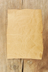 Wrinkled brown paper on wood