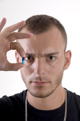 Obraz premium Studio shoot of young caucasian man with pill focus on face