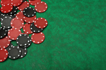 Gambling chips over green felt with copy space.