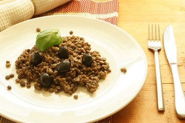 lentil with some organic black olive on a plate