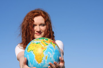 woman holding a globe under blue sky