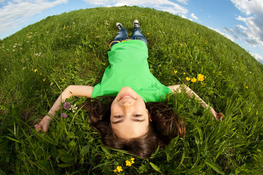 Girl lying on green meadow