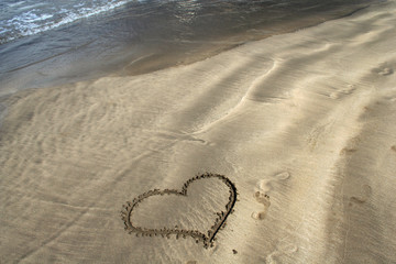 heart on sand on ocean beach