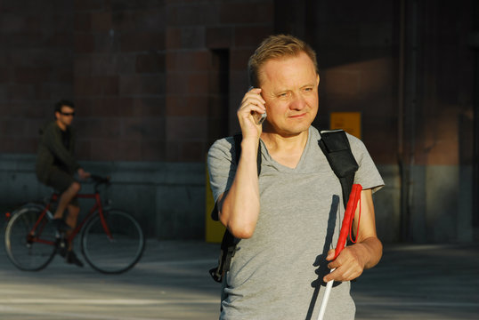 Blinder Mann telefoniert unterwegs