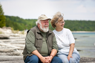 Senior couple sitting at shores edge