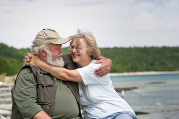 Senior couple sitting at shores edge