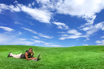 Student Working on a Computer Outdoors in a Beautiful Field of G