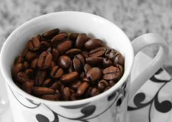 Coffee cup filled with coffee beans