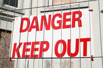 Obraz premium Danger keep out sign on a wire security fence.
