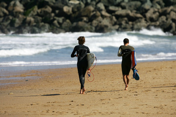 surfer en train de courir sur la plage