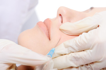 Fototapeta na wymiar Close-up cosmetic injection in woman's cheek