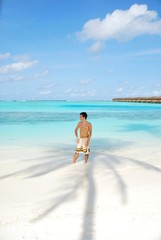 Obraz premium Young man standing on a tropical beach in Maldives