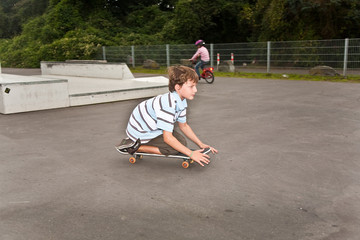 Kinder fahren Skateboard im Skate Park und üben Tricks
