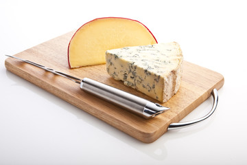 Segments of Brie and Stilton  with a knife on a board