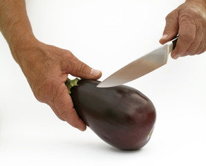 A man prepares to cut an eggplant