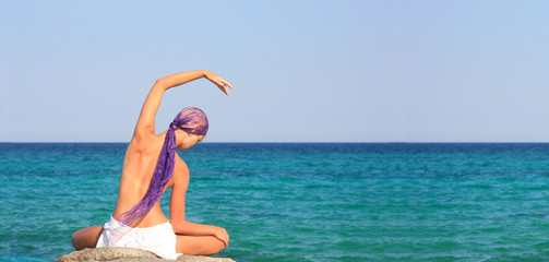 woman meditating in the afternoon by the sea in Greece
