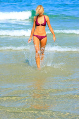 tanned blond woman in bikini in the sea