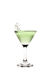 Green liquid splashing in a martini glass.