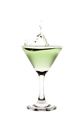 Green liquid splashing in a martini glass.