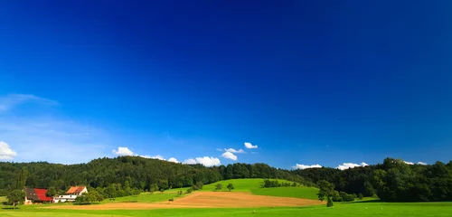 Keuken foto achterwand Donkerblauw zomerlandschap in Duitsland met blauwe lucht en bergen