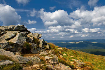 Rocky mountain slide against blue cloudy sky