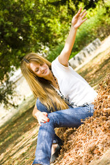 beautiful young woman throwing leaves