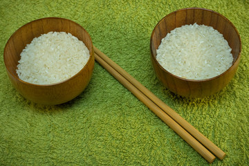bowls with rice and sticks on green mat