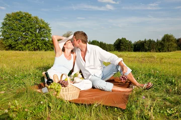  Young man and woman kissing while having picnic © CandyBox Images