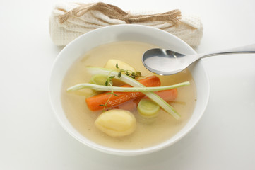 delicious vegetable soup in a white bowl with a spoon