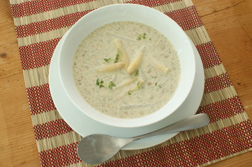 mushroom soup with organic asparagus in a white bowl