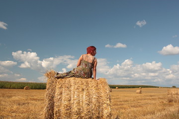 woman sitting in the middle of field