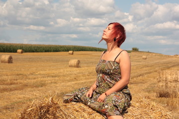 young woman sitting in the field