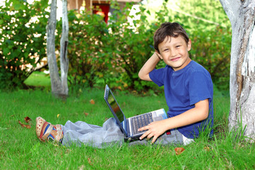 boy with notebook sit at tree outdoors