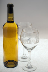 Two crystal glasses and a bottle of white wine