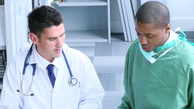 Surgeon and doctor speaking in hospital hall footage