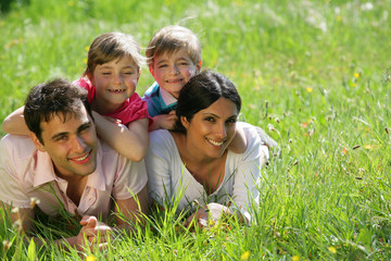 homme et femme avec enfants couchés dans l'herbe