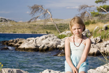little girl sitting on a rocks