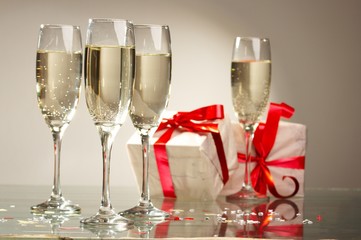 Glasses of champagne, gifts with red tapes and bows