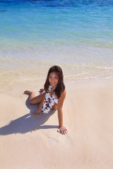 young woman in a white bikini and flower lei on lanikai beach