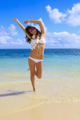 young woman in a white bikini and flower lei on lanikai beach