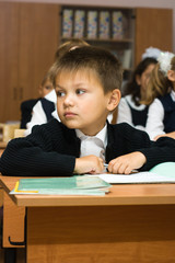 The boy at school at a lesson looks aside