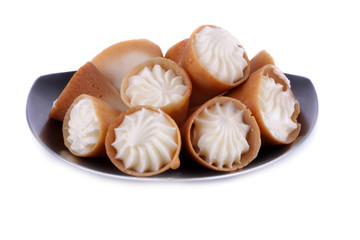 Sugar tubule with a cream on a metal saucer