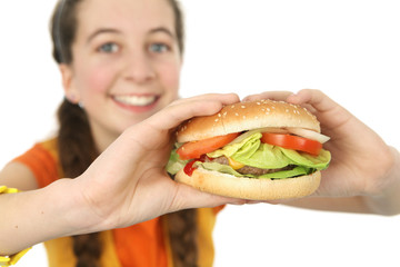 adolescente mange un hamburger