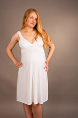 young pretty blonde pregnant in white nightshirt isolated