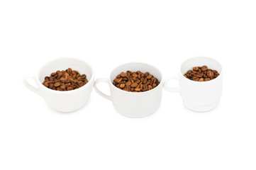 Three white cups full of coffee beans