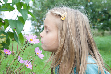 young girl takes the smell of an flower