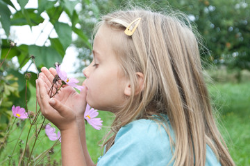 young girl takes the smell of a flower