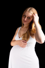 dreaming young pregnant blonde in white nightshirt isolated
