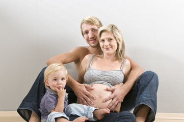 Junge Familie mit Kleinkind sitzen auf dem Fußboden