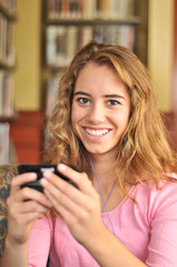 Pretty Female Student Texts while Listining to Music in the Libr